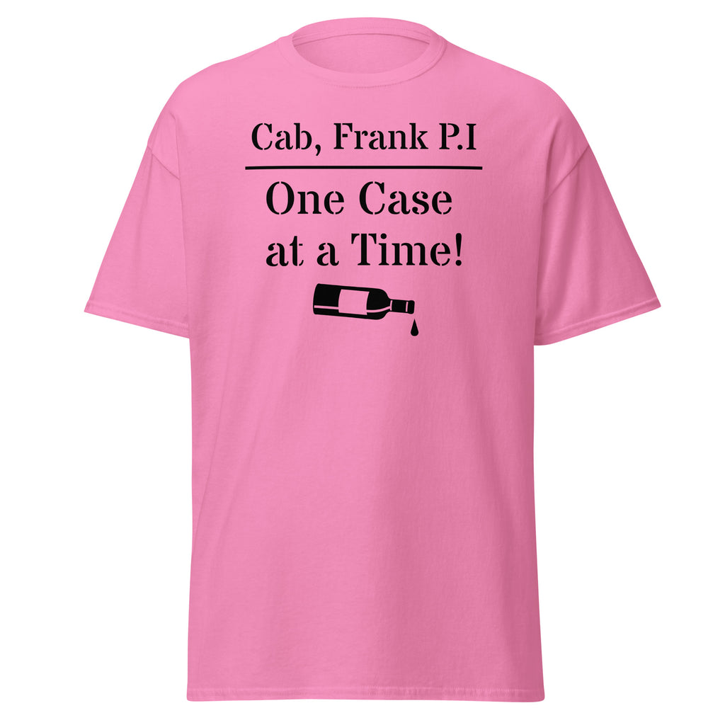 Pink cotton t-shirt with bold black text reading “Cab, Frank. P.I. – One Case at a Time,” styled with vintage wine bottles, corks, and noir props like sunglasses and a magnifying glass to evoke detective satire and vineyard mystery.