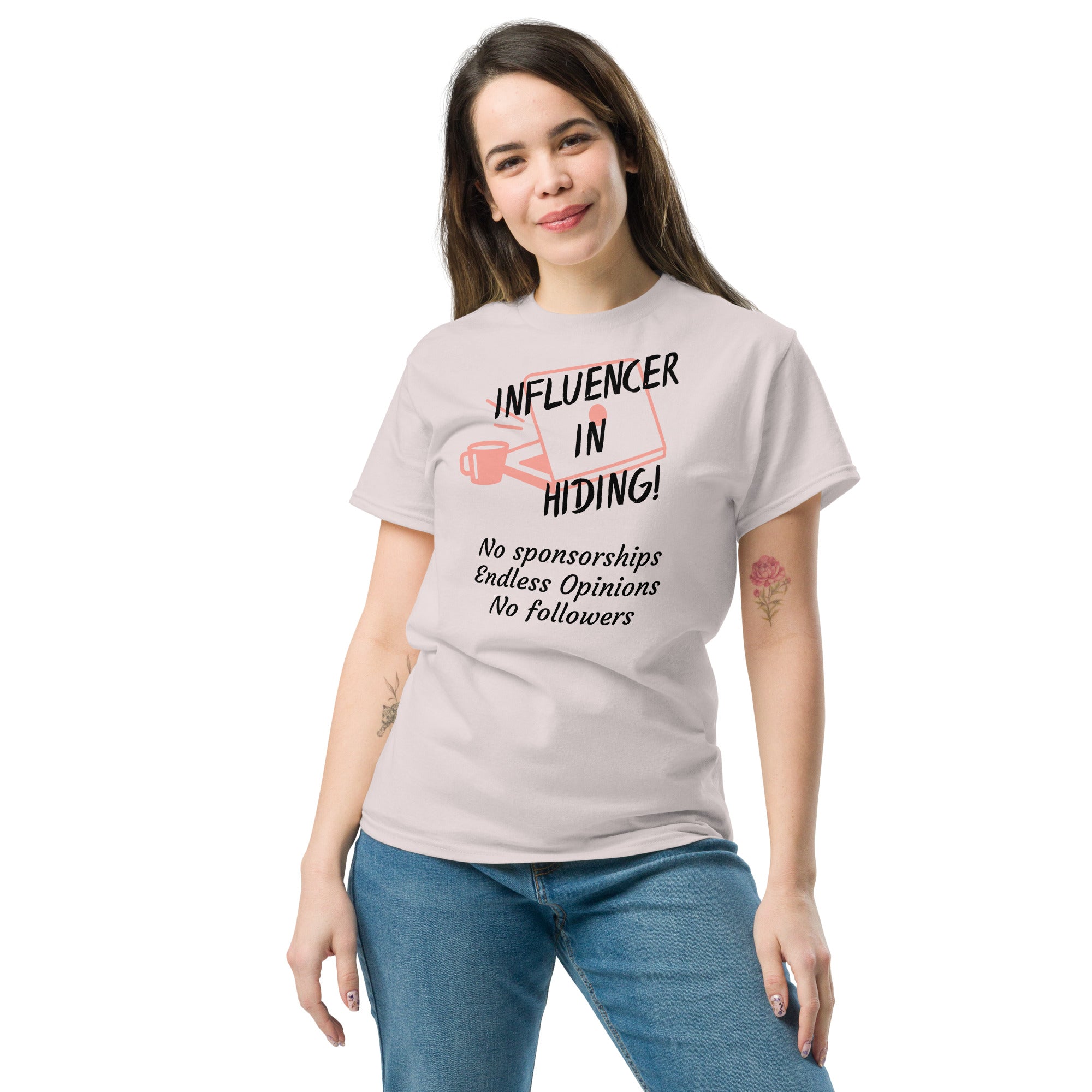 Grey T-shirt featuring a dark red, hand-drawn graphic of a laptop and coffee mug with bold text reading “INFLUENCER IN HIDING.” The design evokes remote work and digital satire—no sponsorships, no followers, just unapologetic opinions.