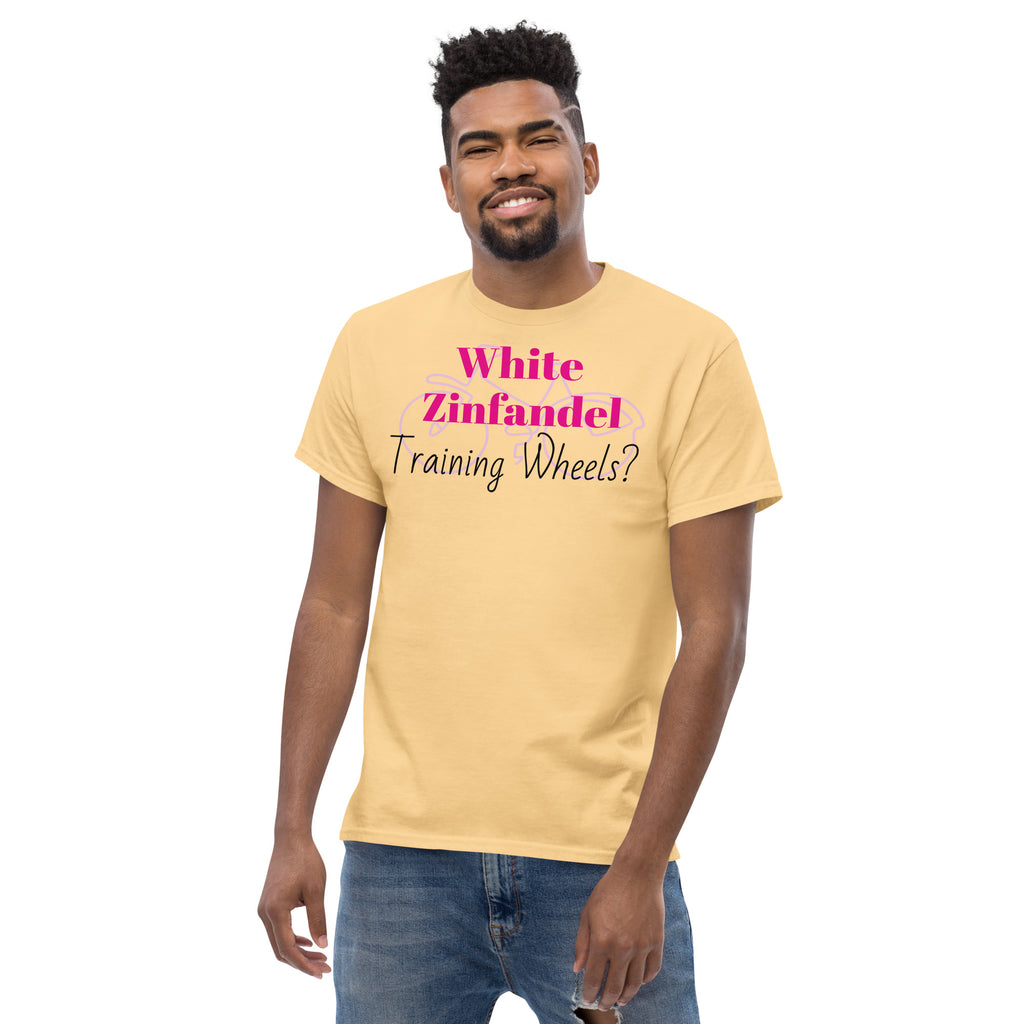 Yellow White Zinfandel – Training Wheels tee laid flat on a rustic wood surface, featuring bold satirical text in vintage script. A soft blush-pink cotton shirt that hints at wine-fueled nostalgia and emotional rites of passage.