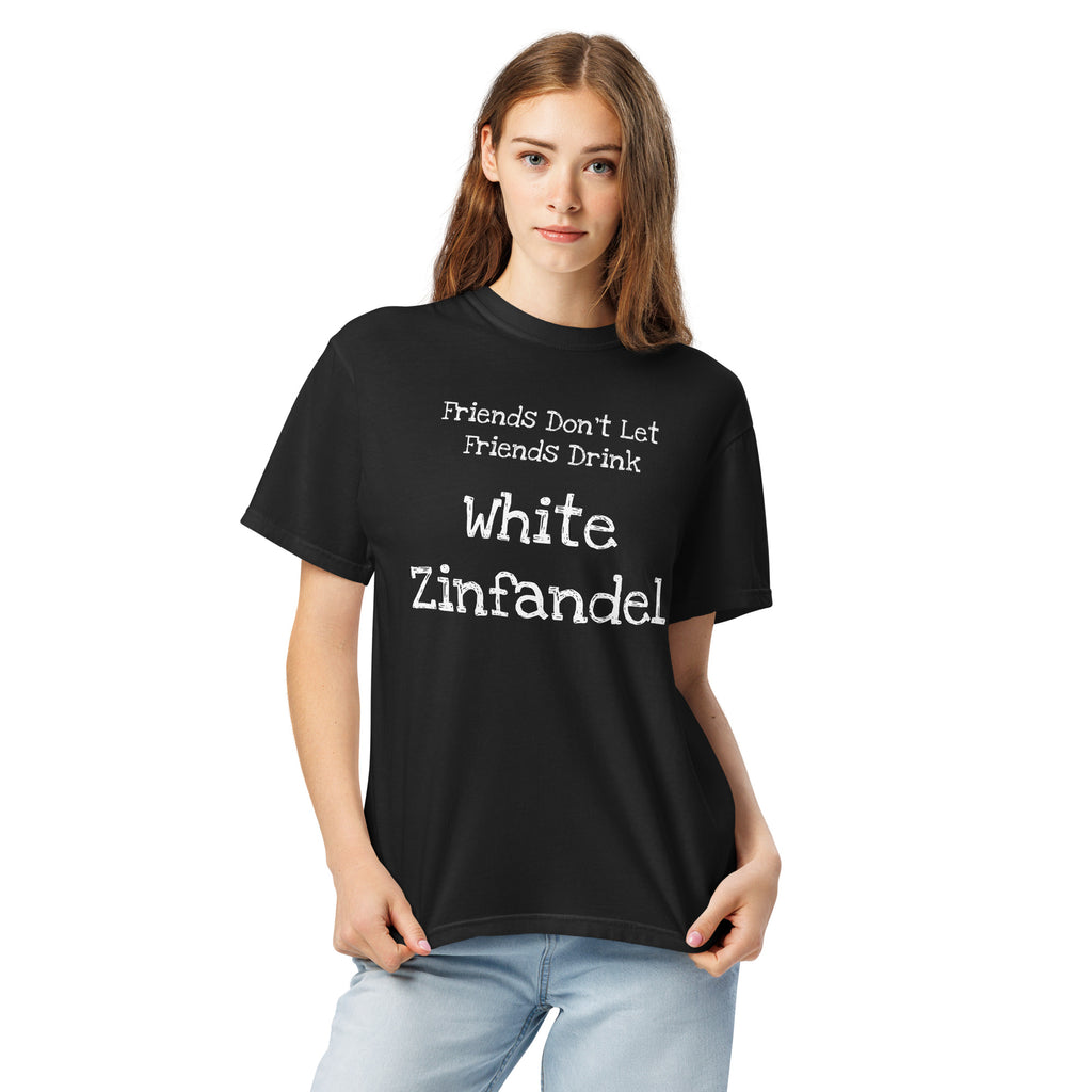 White cotton t-shirt laid flat with bold black text reading “Friends Don’t Let Friends Drink White Zinfandel.” Styled with retro wine props and blush-toned accents for a satirical, nostalgic vibe.