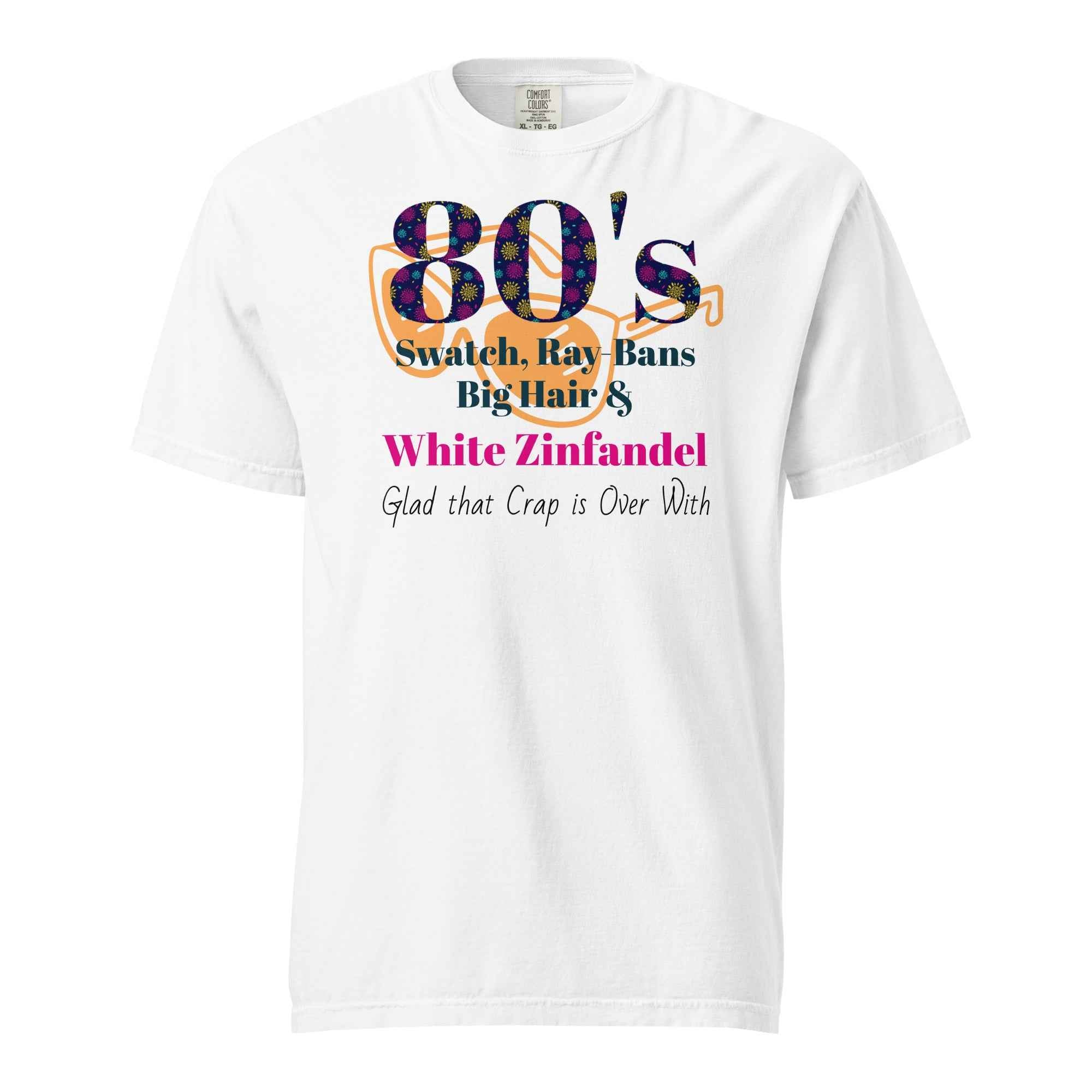 White T-shirt with colorful text listing 1980s trends—Swatch, Ray-Bans, big hair, and White Zinfandel—followed by the punchline “Glad that crap is over with.” A humorous nod to retro excess.
